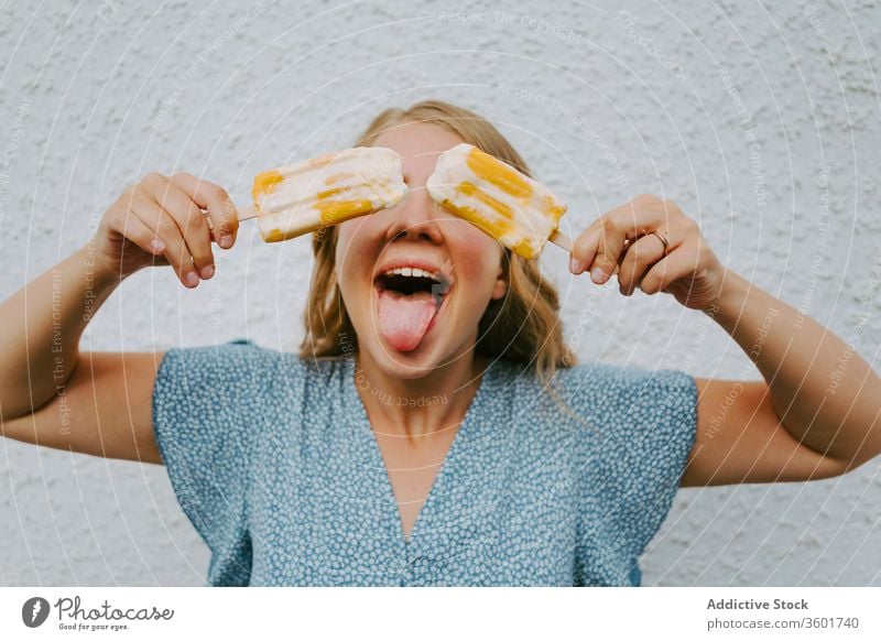 Glückliche Frau mit Eis am Stiel auf weißem Hintergrund Grimasse lustig Gesicht machen Stieleis Speiseeis Spaß haben Kies geschmackvoll heiter Freude lecker