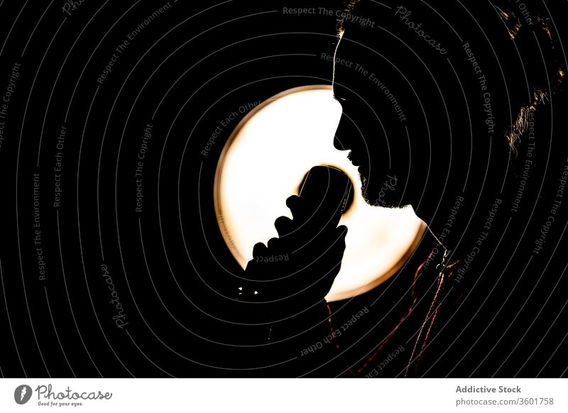 Silhouette eines männlichen Sängers im Studio Mann singen Mikrofon Atelier Musiker dunkel Fähigkeit kreativ Talent Lampe Licht leuchtend ausführen professionell