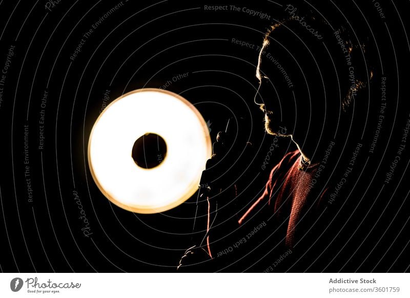 Silhouette eines männlichen Sängers im Studio Mann singen Mikrofon Atelier Musiker dunkel Fähigkeit kreativ Talent Lampe Licht leuchtend ausführen professionell