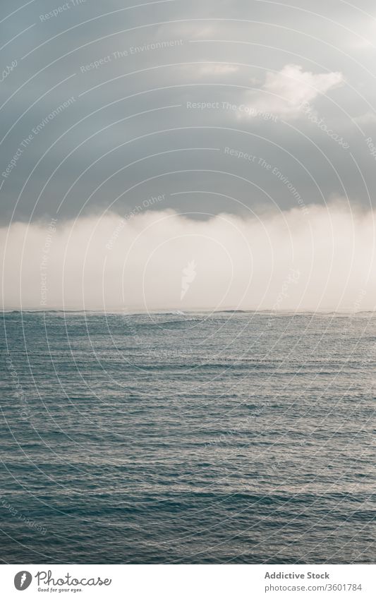 Ruhiges Meer nahe des Hügels unter bewölktem Himmel bei nebligem Wetter MEER Nebel Meereslandschaft Cloud atemberaubend malerisch Natur spektakulär