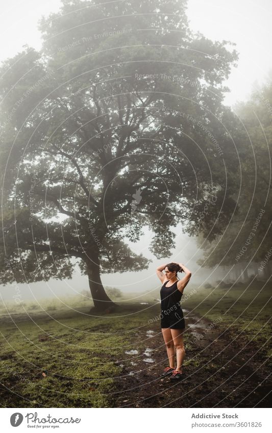 Fitnesssportlerin wärmt sich beim Training im Wald auf Aufwärmen Sportlerin Übung Wälder Morgen Nebel Sportkleidung dreckig Weg Gesundheit Ausdauer Athlet