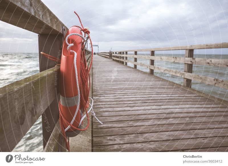 Seebrücke mit Rettungsring Steg Küste Wellen Wolken Sturm