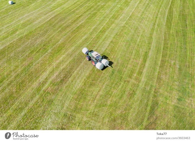 ein Traktor macht Heuballen auf einem Feld Traktor von oben historischer Traktor Heu machen grüner Traktor Traktor auf einem Feld landwirtschaftlich