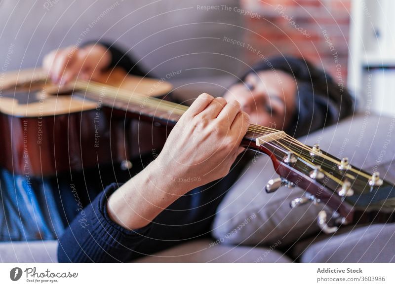 Frau spielt Gitarre und lernt mit Online-Kursen Musik Lifestyle im Innenbereich Lernen Spielen E-Learning Menschen Gitarrenspieler Erwachsener