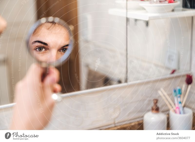 Hübscher Mann beim Blick in den Spiegel Bad Auge Morgen heimwärts hell ernst Routine täglich frisch männlich stehen Hygiene Stil Pflege Sauberkeit Zeitgenosse