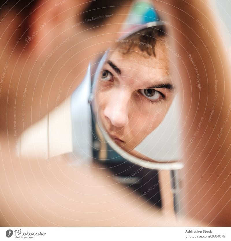 Hübscher Mann beim Blick in den Spiegel Bad Morgen heimwärts hell ernst Routine täglich frisch männlich stehen Hygiene Stil Pflege Sauberkeit Zeitgenosse modern