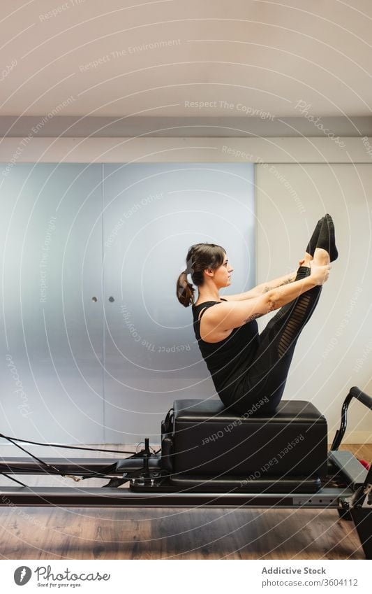 Sportlerin macht Übungen zum Pilates-Reformer Training Maschine Unterleib Sportkleidung Gesundheit Frau stark Athlet Wellness Sportbekleidung passen