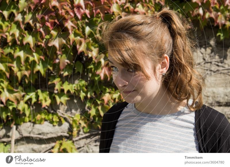 Skeptischer Blick Frau Augen Mimik Haare Mauer Efeu Sommer Yorkshire Wand Sonne Schatten fröhlich Spaß Urlaubsstimmung