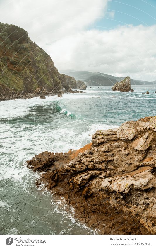 Rauhe Felsen, die von Meereswellen umspült werden und bei Tageslicht Schaum bilden winken MEER atemberaubend malerisch spektakulär Landschaft schäumen