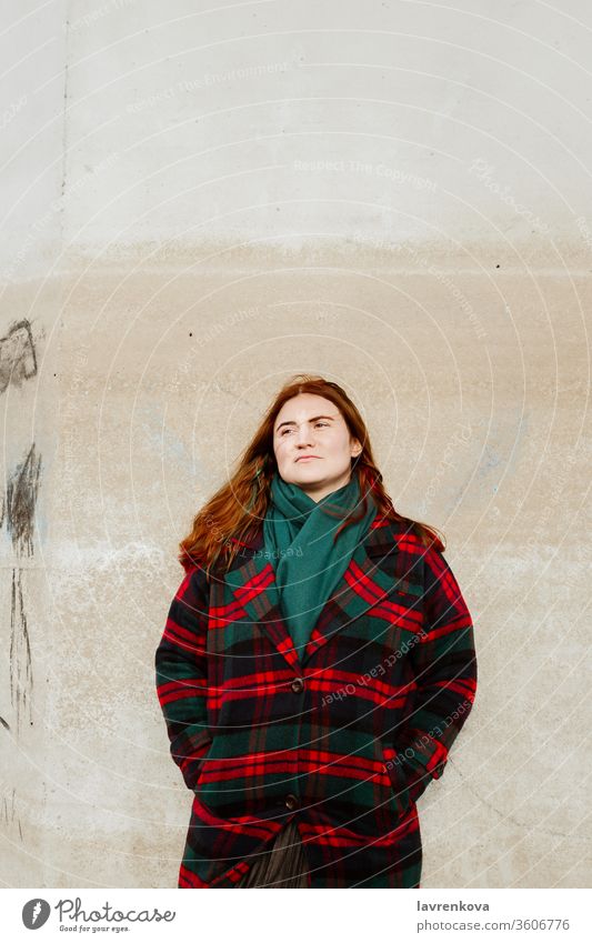 Hündin mit roten Haaren in kariertem Mantel im Freien stehend Frau rote Haare Herbst Plaid allein Lifestyle Erwachsener geprüft Wand Wegsehen Saison Winter