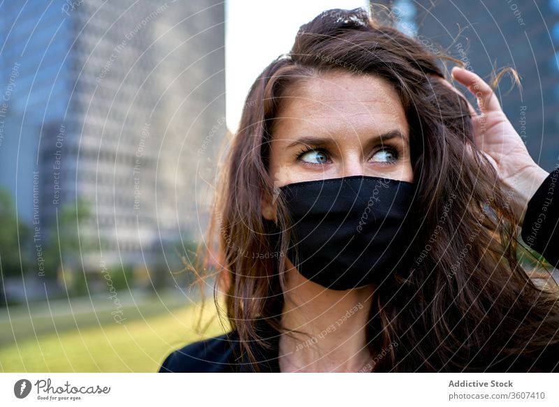 Seriöse Frau mit medizinischer Maske in der Stadt Seuche Coronavirus Mundschutz Großstadt Bund 19 behüten verhindern Sicherheit Stadtzentrum ernst modern