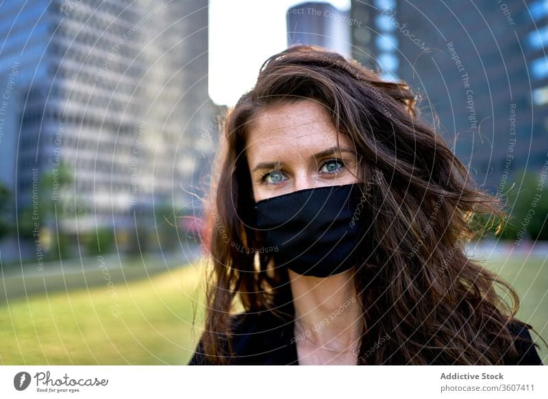 Seriöse Frau mit medizinischer Maske in der Stadt Seuche Coronavirus Mundschutz Großstadt Bund 19 behüten verhindern Sicherheit Stadtzentrum ernst modern