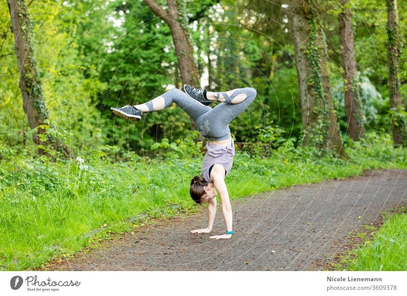 Junge Frau macht einen Handstand als Fitnesstraining Training Sport passen im Freien Natur außerhalb aktiv Bewegung rennen Gesundheit Lifestyle Übung Joggen