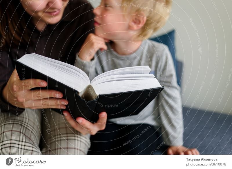 Mutter und Kind lesen Buch und lächeln Familie heimwärts Zusammensein Glück Kindheit Menschen Eltern Frau Kaukasier Bildung Fröhlichkeit im Innenbereich Mama