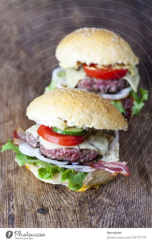 hausgemachte Hamburger auf rustikalem Holz Burger saftig zwei Rindfleisch Essen Käse Salat Hintergrund Fleisch lecker amerikanisch Tomaten weiß Zwiebel Blick