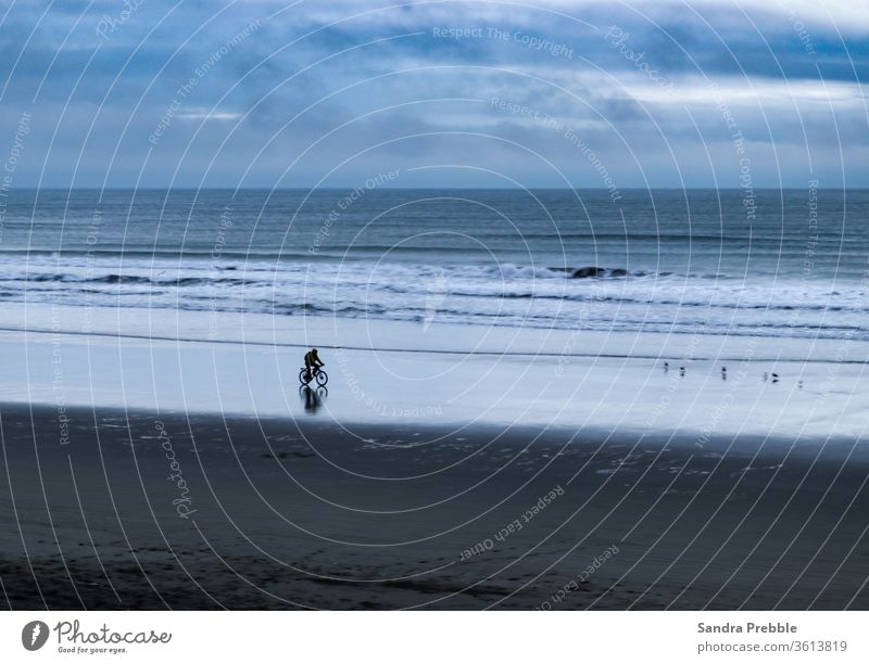 Ein einsamer Radfahrer radelt am frühen Morgen den leeren Strand hinunter 2020 Christchurch Neu Brighton Pier Sandra Prebble Morgendämmerung Sonnenwende