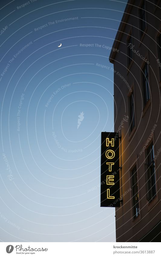 Hotel – Leuchtbuchstaben an der Hotelfassade. Nachthimmel mit Mond. Schriftzug leuchtschrift Fenster Sichelmond Außenaufnahme Abend Farbfoto Menschenleer blau