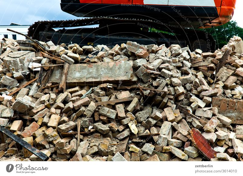 Abriss mit Bagger abriss außen bagger bau baugewerbe bauindustrie bauschutt baustelle froschperspektive gebäude gewerk kettenfahrzeug menschenleer montage