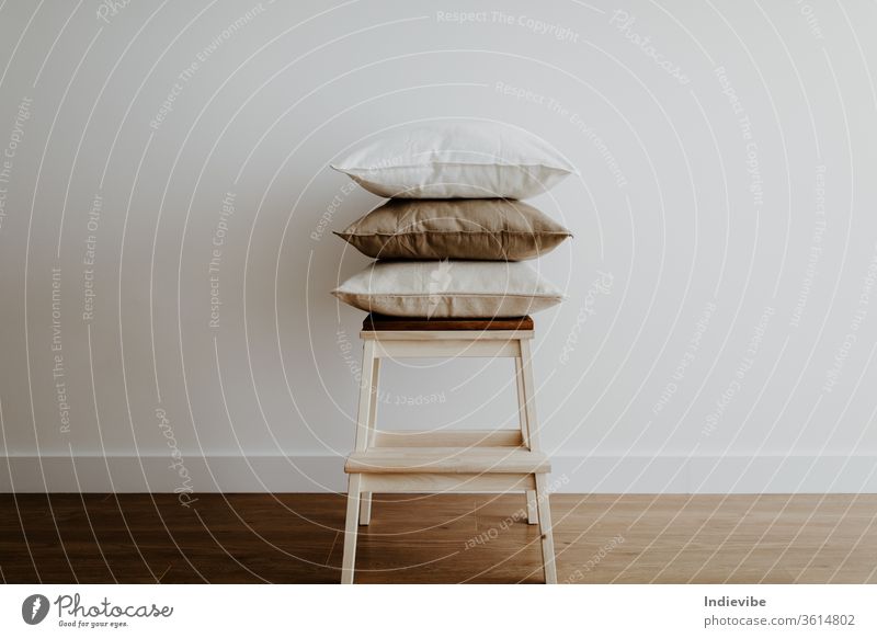 Hocker mit Kissen in einem leeren Raum Möbel sehr wenige Appartement Hintergrund beige braun Stuhl Zeitgenosse gemütlich gemütliches Zuhause Innenbereich Dekor