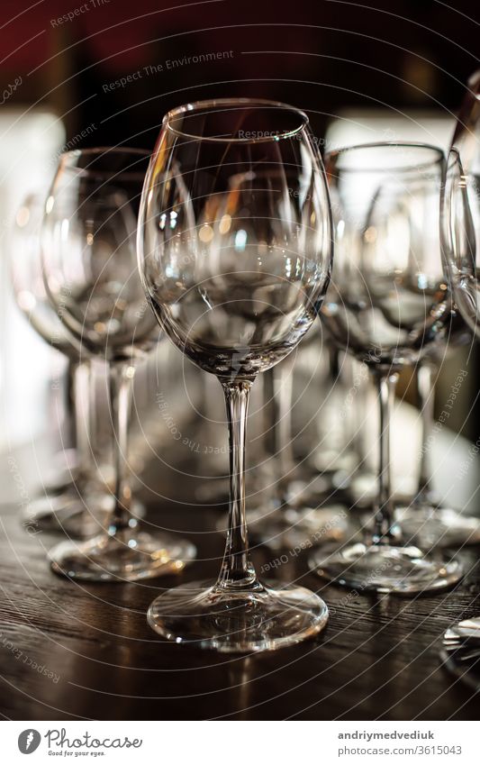 leere Weingläser. Schöne neue Gläser für Wein aus Glas stehen in gleichmäßigen Reihen auf einem Holztisch in einem Restaurant. selektiver Fokus Alkohol Bar