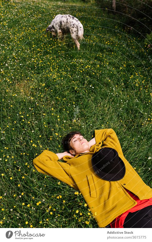 Fröhliche Frau mit Hund auf der Wiese genießen Sonne Zusammensein Lügen heiter Blume Inhalt Asturien Spanien Eckzahn Natur Glück Tier Haustier Sommer heimisch