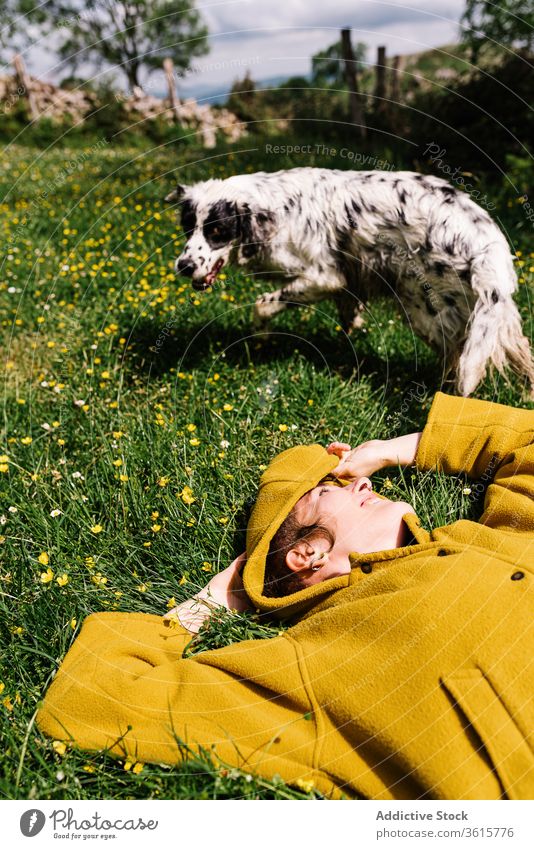 Fröhliche Frau mit Hund auf der Wiese genießen Sonne Zusammensein Lügen heiter Blume Inhalt Asturien Spanien Eckzahn Natur Glück Tier Haustier Sommer heimisch