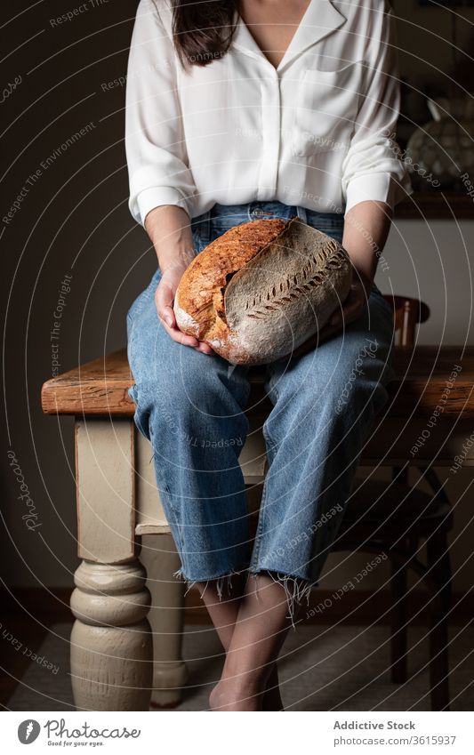 Erntehelferin mit frischem Brot lecker gebacken Frau Küche Bäckerei Tisch Brotlaib Ernährung selbstgemacht heimwärts Gebäck Lebensmittel Tradition sitzen