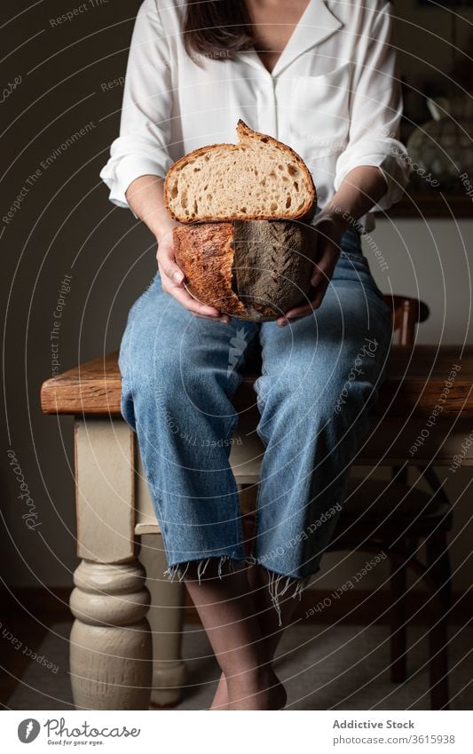 Erntehelferin mit frischem Brot lecker gebacken Frau Küche Bäckerei Tisch Brotlaib Ernährung selbstgemacht heimwärts Gebäck Lebensmittel Tradition sitzen