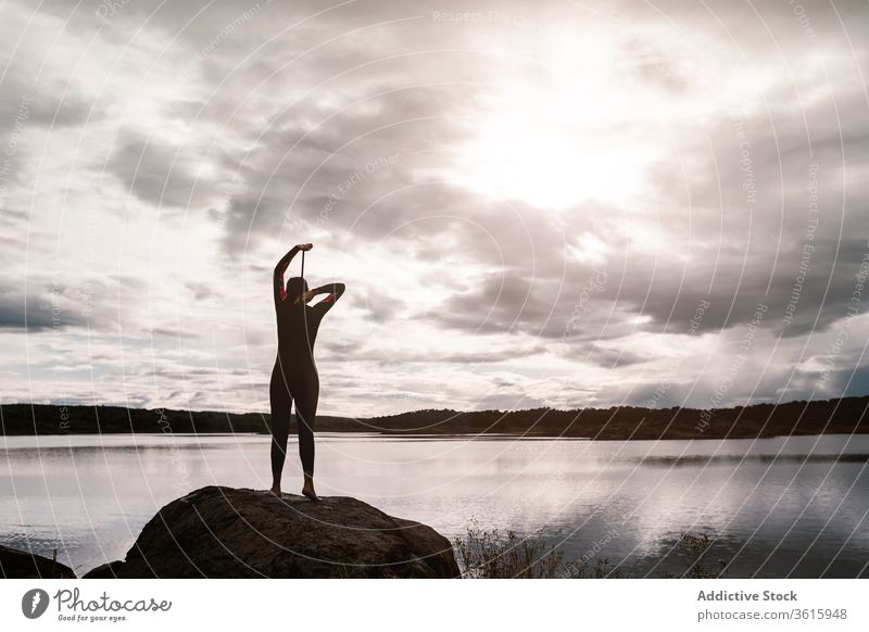 Athletin im Neoprenanzug an ruhigem Seeufer Frau Taucher Wasser Badeanzug Natur Ufer Reißverschluss extrem Umwelt Schwimmer Inspiration wolkig befestigen