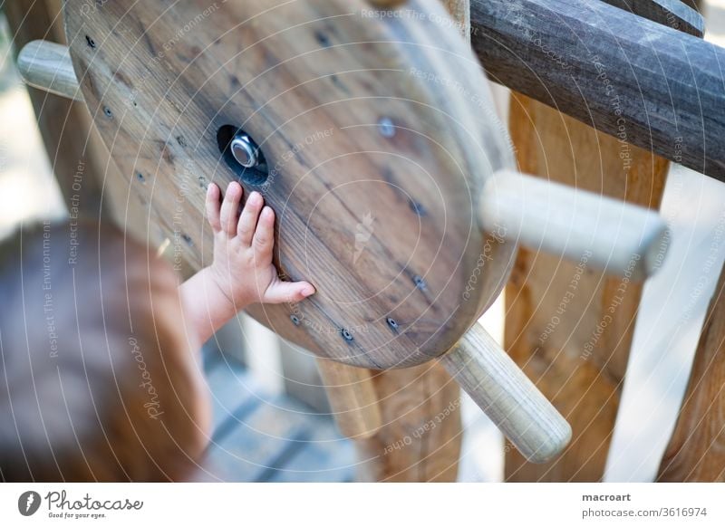 Die Welt erobern knd spielen spielplatz schiff holzspielplatz entdecken schiffsreise steuer steuerrad toben welt hand nahaufnahme detailaufnahme finger