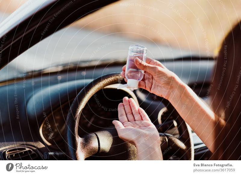 nicht erkennbare Frau, die vor der Fahrt im Auto ein desinfizierendes Alkoholgel verwendet hat. Konzept der sauberen Hände Desinfektionsmittel Gel PKW