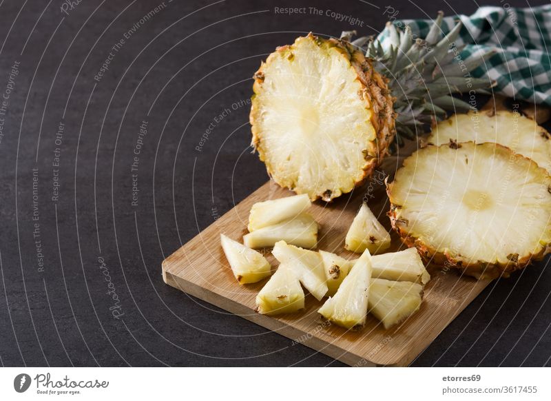 Frische Ananasscheiben auf Schneidebrett und schwarzem Hintergrund. Leerzeichen kopieren geschnitten Dessert Diät frisch Frucht Gesundheit saftig Ernährung