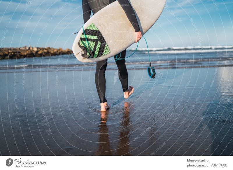 Surfer, der mit seinem Surfbrett ins Wasser geht. Mann Brandung Sport Surfen MEER Meer im Freien sportlich malerisch Küstenlinie Wellen Hintergrund Abenteuer