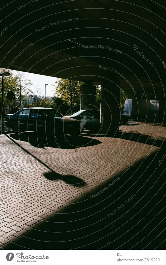 tatort Parkplatz Auto parken Verkehr Straßenverkehr PKW Verkehrsmittel dunkel Fahrzeug geheimnisvoll Stillstand Brücke Schatten Menschenleer Außenaufnahme