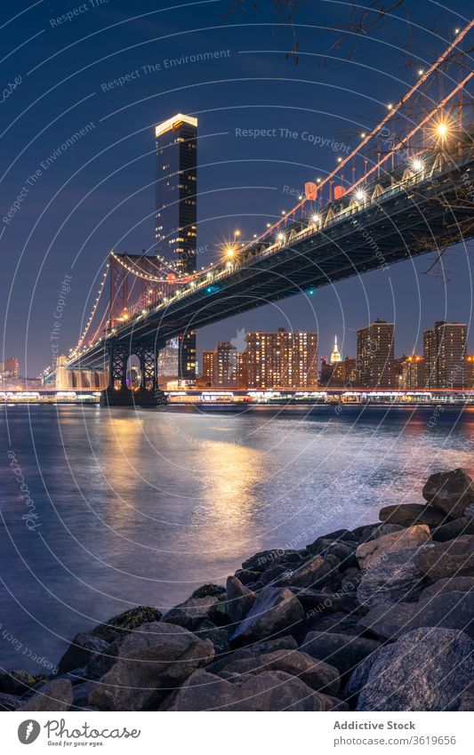 Beleuchtete Brücke über einen Fluss in einer nächtlichen Stadt Brooklyn Architektur Nacht Gebäude Struktur Design Stil leuchten Großstadt Wasser