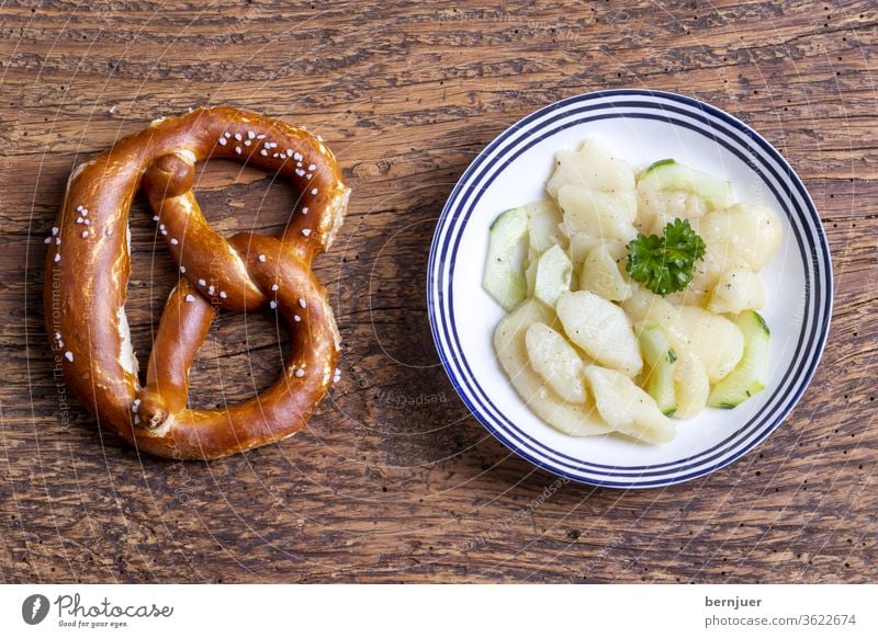 bayerischer Kartoffelsalat auf Holz frisch Breze Brezel Aufsicht Essen grün Dressing Gemüse Zwiebel Salat Mahlzeit Abendessen weiß Schüssel Deutsch Gewürze