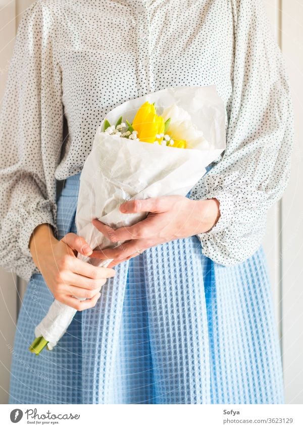 Frau hält Tulpenstrauß. Der Tag der Frau Blume Haufen Mutter geben Frühling Ostern Hände geblümt weiß gelb Dame März Geschenk Einladung Gruß Postkarte