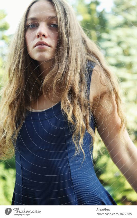 Portrait einer jungen Frau auf dem Balkon vor Bäumen Blauer Himmel intensiv Mädchen Erwachsene Porträt Tag Haut Sonnenlicht selbstbewußt Zentralperspektive