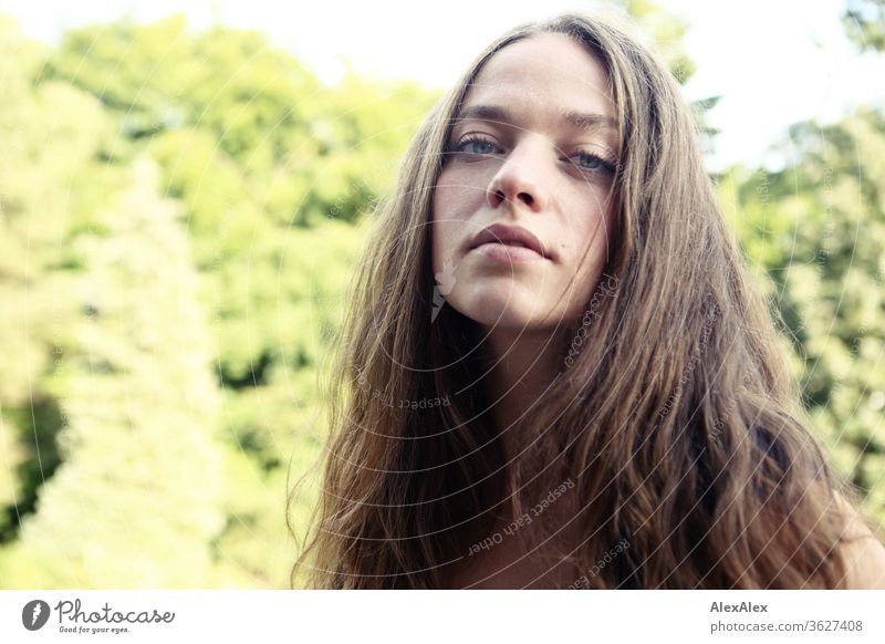 Portrait einer jungen Frau auf dem Balkon vor Bäumen Blauer Himmel intensiv Mädchen Erwachsene Porträt Tag Haut Sonnenlicht selbstbewußt Zentralperspektive