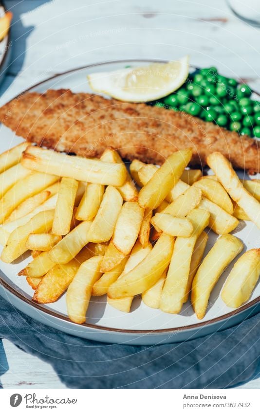 Fisch und Pommes Frites mit Erbsen Chips Lebensmittel Schellfisch Seehecht ramponiert Dorsch Englisch Knusprig Filet Abendessen Briten gebraten Mahlzeit