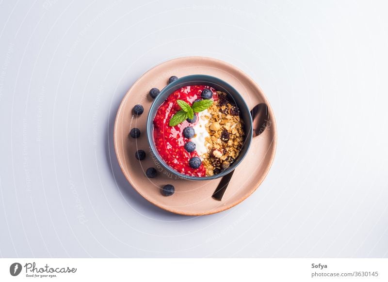 Joghurtschale mit Himbeeren und Granola Smoothie Schalen & Schüsseln Müsli Beeren farbenfroh Farbe Blaubeeren Pastell hölzern Hintergrund Muttern Frühstück