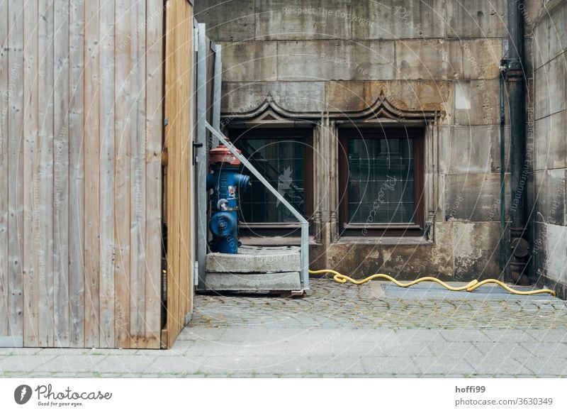 Hydrant, Schlauch und Bretterzaum vor historischer Fassade Bretterzaun Historische Bauten Baustelle Altstadt Bauwerk Architektur urbanes Stillleben