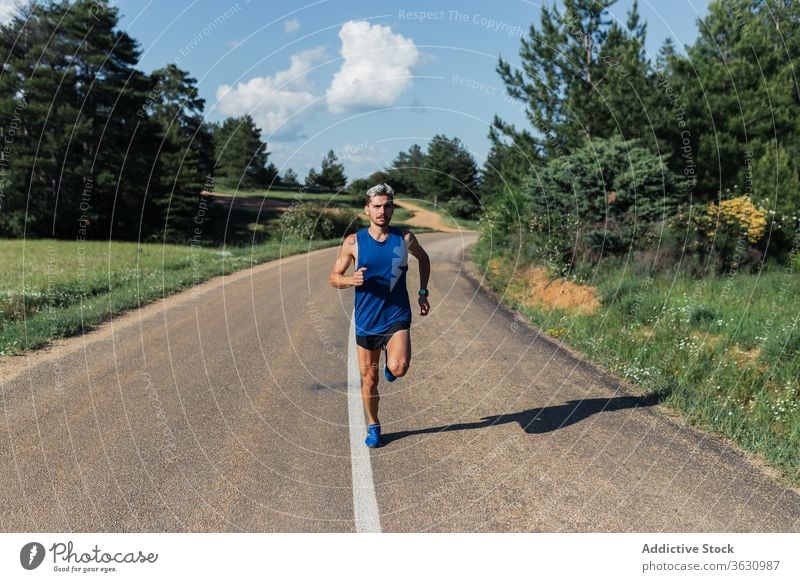 Entschlossener Mann läuft während des Trainings auf der Straße laufen schnell Übung Fitness jung Sport passen Aktivität Sportbekleidung joggen urban Gesundheit