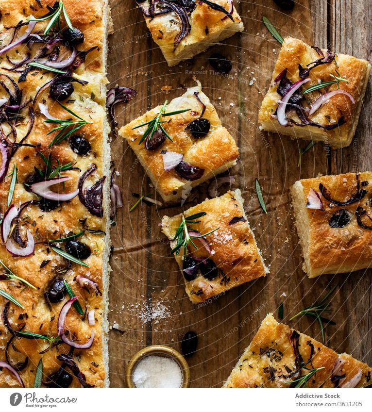 Focaccia mit schwarzen Oliven und Kräutern auf Holztisch hölzern Brot Hefe oliv italienisches Brot Focaccia-Brot Bestandteil handgefertigt Zwiebeln