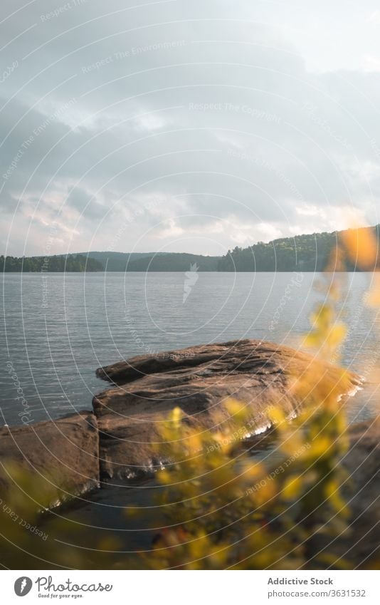 Steiniges Ufer in der Nähe eines ruhigen Sees bei bewölktem Tag Natur reisen Freiheit Harmonie Landschaft genießen Wasser Felsen Reise Tourismus Abenteuer