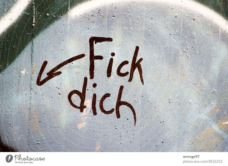 Unklare Sachlage - Fick Dich mit schwarzer Farbe und einem Hinweispfeil an eine graue Mauer gesprüht Graffito sprayen schwarze Farbe Wand fick dich