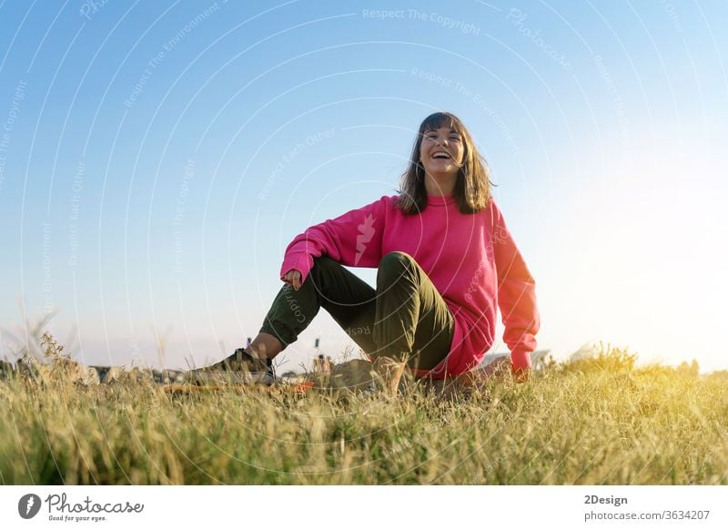 Schöne junge Frau mit Skateboard. urban 1 Spaß Mädchen Mode Textfreiraum 20s Holzplatte brünett niedlich Skateboarding Freizeitkleidung Sonnenuntergang stylisch