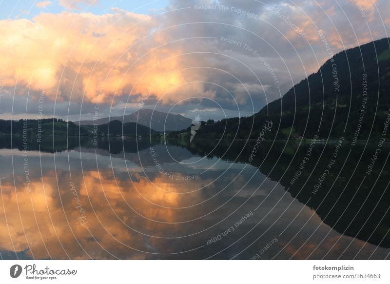 bewölkter gelber Abendhimmel an Hügelkette mit Spiegelung im See abendhimmel Dämmerung Wolken Spiegelung im Wasser Spiegelung der Wolken im See Seeufer