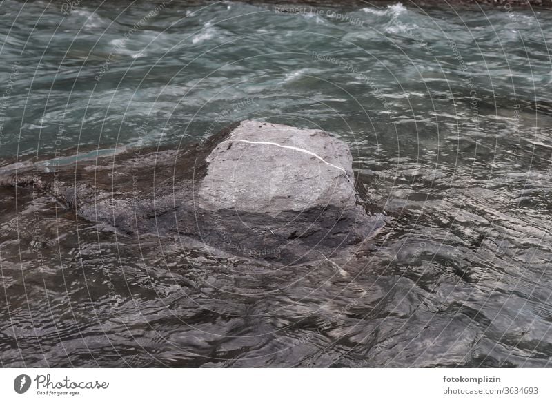 Stein mit weißem Strich im Fluss Steinblock Strichellinie Linie fließen strömen liniert Grenzstein grau Strömung Felsen Wasser Natur Bewegung Richtung Bach