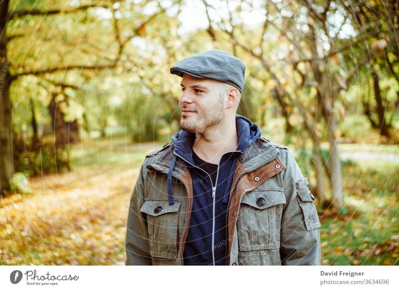 Mann, der in einem herbstlichen Wald oder Park steht. Herbst, Outdoor und Lifestyle-Konzept. Menschen Natur jung Person gutaussehend fallen männlich Porträt